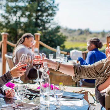woman sitting around a table wine tasting outside